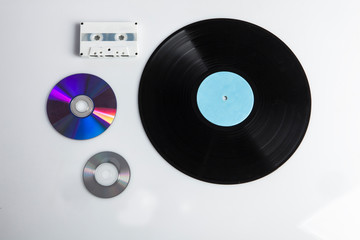 Confronto tra varie epoche musicali con dischi in vinile , cd , cassette e pen-drive, isolati su sfondo bianco - obrazy, fototapety, plakaty
