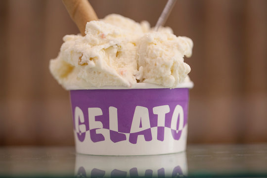 coppetta di gelato con la scritta in Italiano "Gelato" , isolata su sfondo scuro