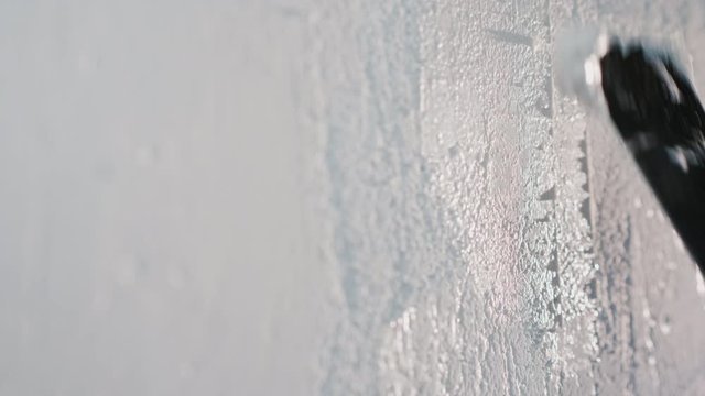 The master applies putty on a white wall. Repair and decoration work in the house