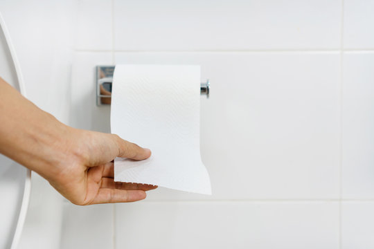 Close up of Asian woman hand  pulling paper in bathroom