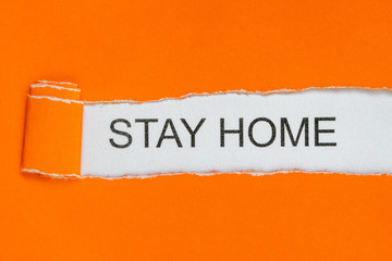 Torn orange paper with words STAY HOME