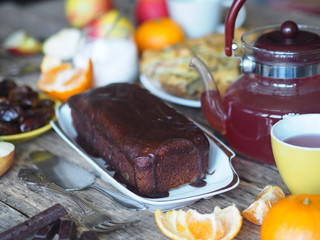 Food background.Homemade baking chocolate pumpkin muffin, iced on a wooden table with food.