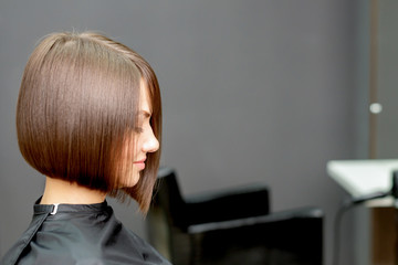 Woman with short hairstyle in hair salon with copy space.