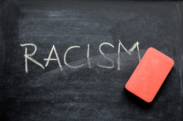 erasing racism, hand written word on blackboard being erased concept