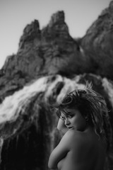 mujer atractiva desnuda en una cascada en la naturaleza blanco y negro