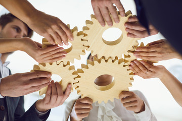 Group of businessmen with gears at the table at the workplace in the office.