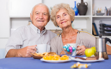 Obraz na płótnie Canvas Happy mature couple drinking tea in kitchen