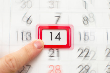 The man points his finger to the date and the calendar is the 14th, closeup and blur. Focus on the...