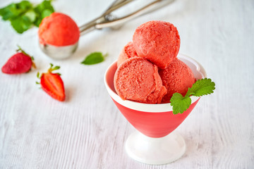 Homemade strawberry ice cream , sorbet in ceramic cone with mint leaves. Closeup