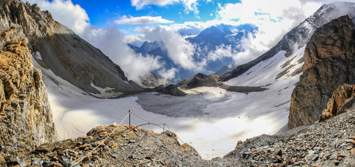 Dramatic panoramic view of a snow filled valley in the swiss alps as seen from the top of Barrhorn...