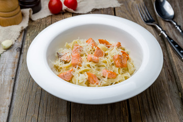 tagliatelli pasta with salmon on wooden table