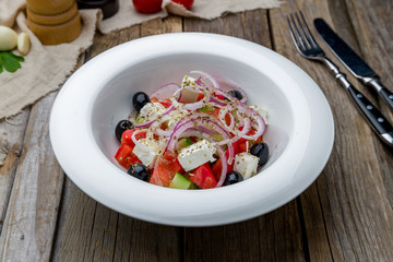 Greek salad with feta on wooden table
