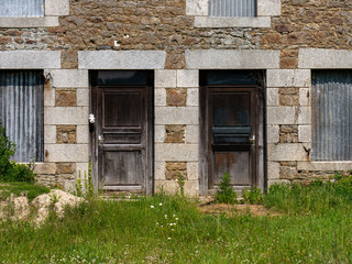 Fototapeta na wymiar two old front door to the building, stone wall, grass