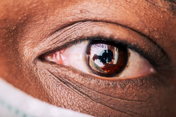 close up of aftican american brown eye wearing a protective surgical mask