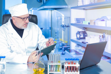 Laboratory Assistant. Virus sample on a laboratory bench. Doctor records the test results. Concept - laboratory for testing patients. Testing for verification of nucleation. Fever research.