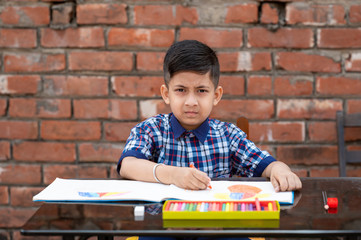 Indian schoolkid in uniform drawing and learning painting in classroom, Indian primary school education concept.