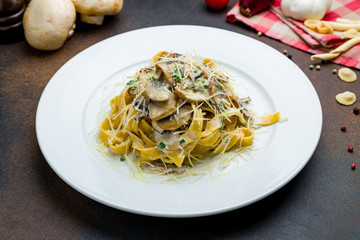 fettuccine with porcini mushrooms and parmesan on a white plate