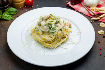 tagliatelli pasta with salmon on a white plate