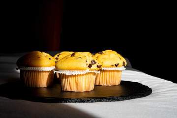 Chocolate muffins on a black plate.