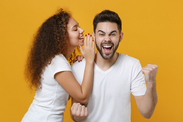 Happy young couple friends european guy african american girl in white t-shirts posing isolated on...