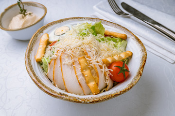 Salad caesar with chicken on white plate