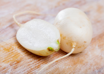 Fototapeta na wymiar Cut fresh white turnip on wooden table in home kitchen