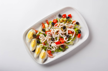 healthy salad in a white plate on a white background. Healthy eating