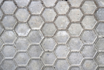 rough gray slabs or tiles with hexagonal shape of dirty street floor of a road - urban background