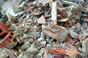 construction container with broken bricks from a destroyed wall, sand, tiles and other garbage
