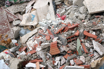 construction container with broken bricks, cardboard, plastics and other garbage in the environment