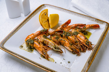 Tiger prawns on the grill with pesto sause and lemon