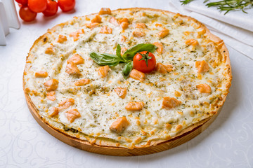 Pizza with salmon and Philadelphia cheese on white table