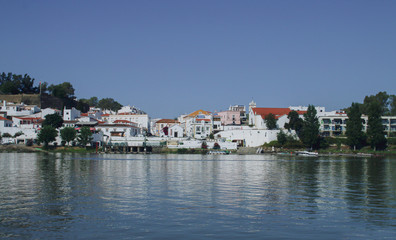 Fototapeta na wymiar Alcoutim, un pequeño pueblo de la región del Algarve en Portugal. Vista de su puerto deportivo y casas a orillas del río Guadiana desde la orilla española en Sanlúcar de Guadiana.