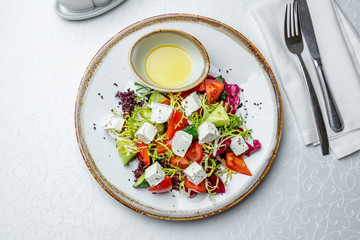 Greek salad with feta on white table