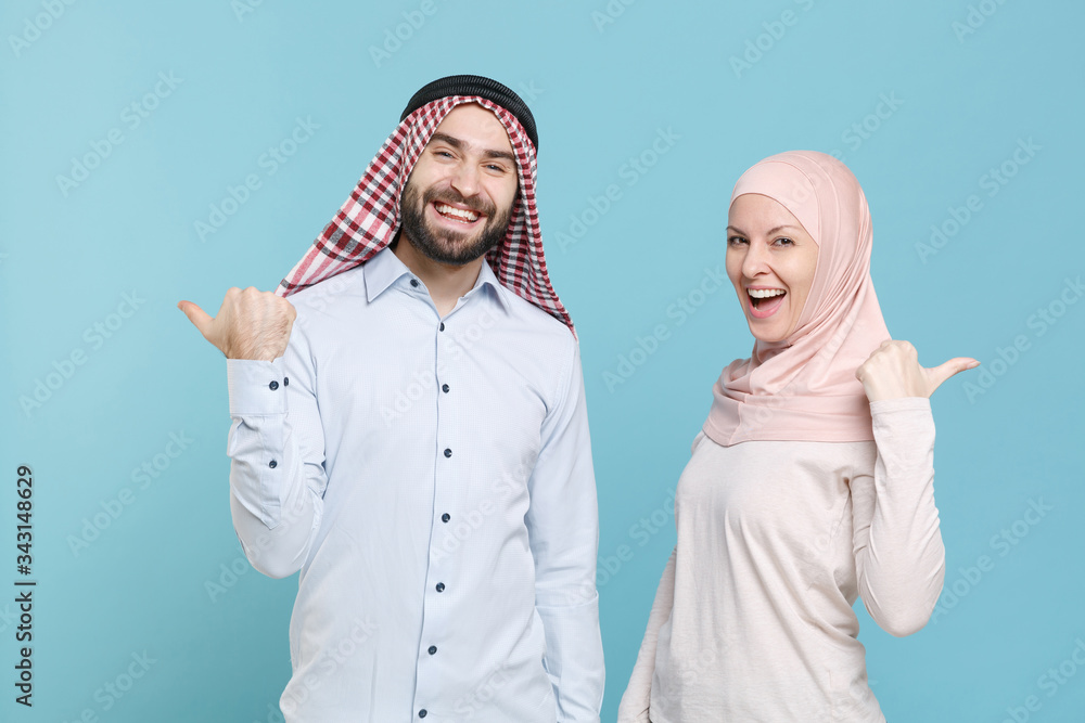 Wall mural cheerful young couple friends arabian muslim man wonam in keffiyeh kafiya ring igal agal hijab cloth