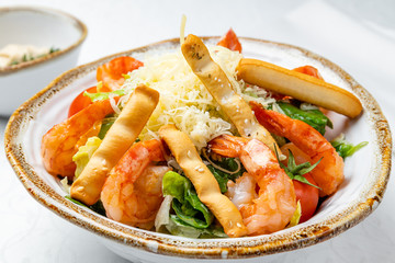 salad caesar with shrimps on white plate