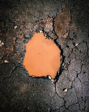 Directly Above View Of Water In Pothole On Street