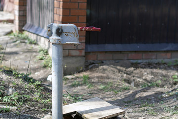 An old plumbing device with a lever mounted on the street.