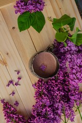 bouquet of lilac flowers and a cup of cocoa on a wooden table
