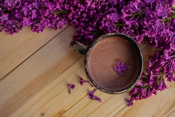 lavender flowers and a cup of cocoa on wooden background