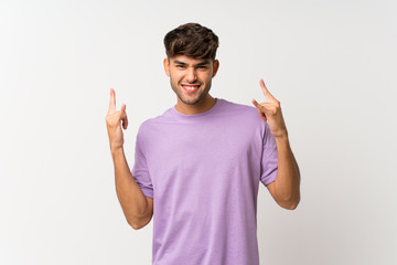 Young handsome man over isolated white background making rock gesture