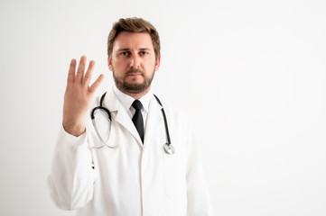 Male doctor with stethoscope in medical uniform counting four with her fingers