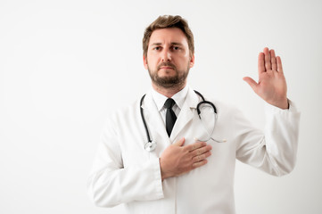 Male doctor with stethoscope in medical uniform showing oath