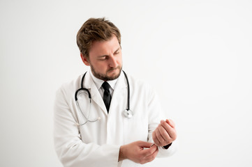 Male doctor with stethoscope in medical uniform arranges his uniform