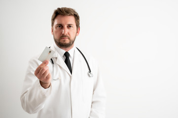 Male doctor with stethoscope in medical uniform showing card