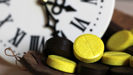 Medical yellow tablets and watches with Roman numerals, ancient medicine