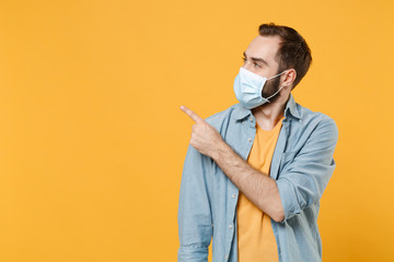 Young man in sterile face mask posing isolated on yellow background studio portrait. Epidemic...