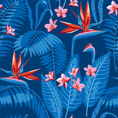 Seamless pattern of tropical leaves and flowers of plumeria and strelitzia on a dark blue background.