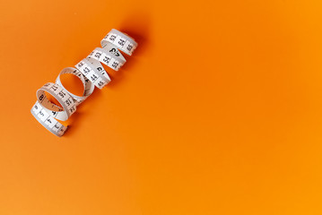 Orange background with centimeter. Diet and healthe care concept. Copy space. Place for text and...