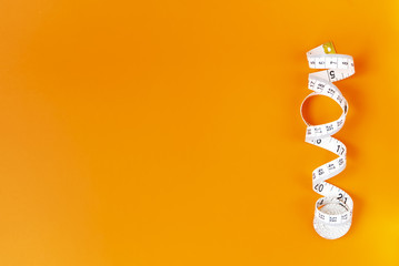 Orange background with centimeter. Diet and healthe care concept. Copy space. Place for text and design.